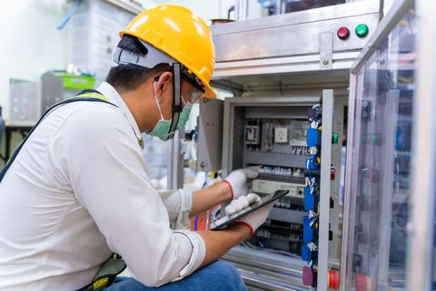 Teknisi memeriksa panel listrik rutin
